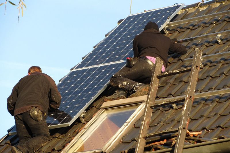 Solar installers working on a rooftop photovoltaic array